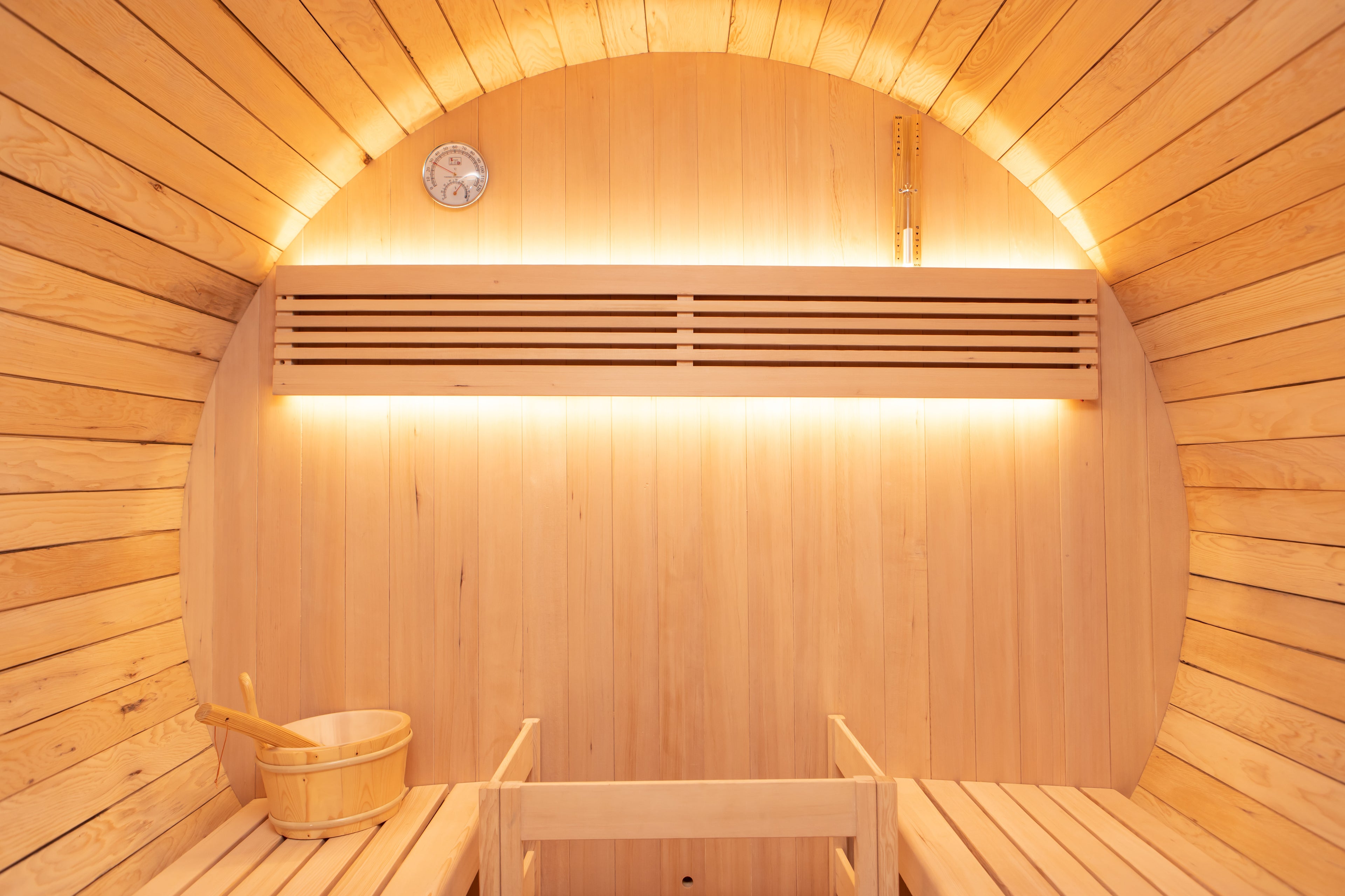 Sho-Sugi-Ban Black Barrel Sauna interior with benches and a bucket.
